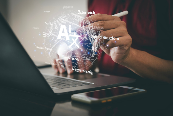 persona escribe en computadora, y sobre ella está una burbuja con nombres de diferentes idiomas, como inglés, francés, español, alemán.
