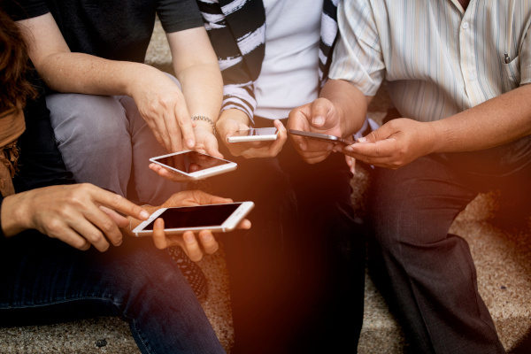 diferentes personas usando un celular
