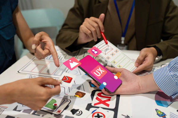 personas revisando dibujos de prototipos de una aplicación para un celular