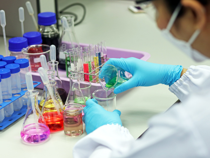 mujer trabaja en laboratorio con tubos de ensayo