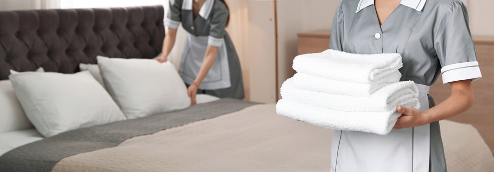 El personal de servicio coloca toallas limpias en la habitación del hotel