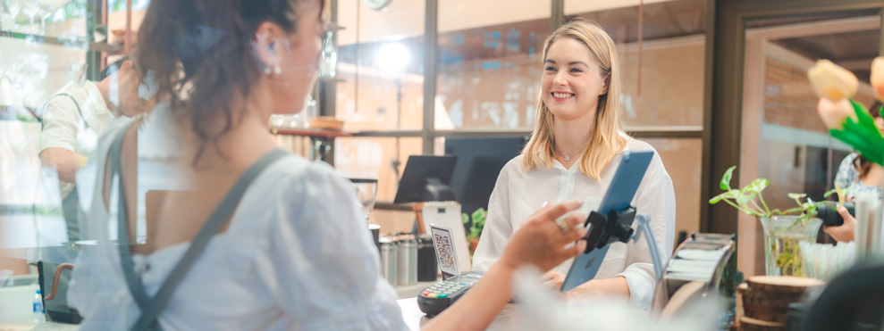 Una camarera atiende con una sonrisa a sus clientes en una cafetería