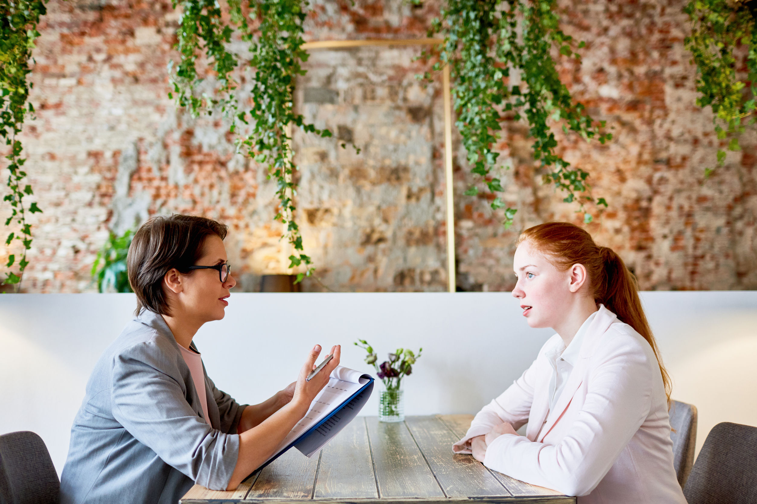 dos mujeres hablan sentadas a la mesa