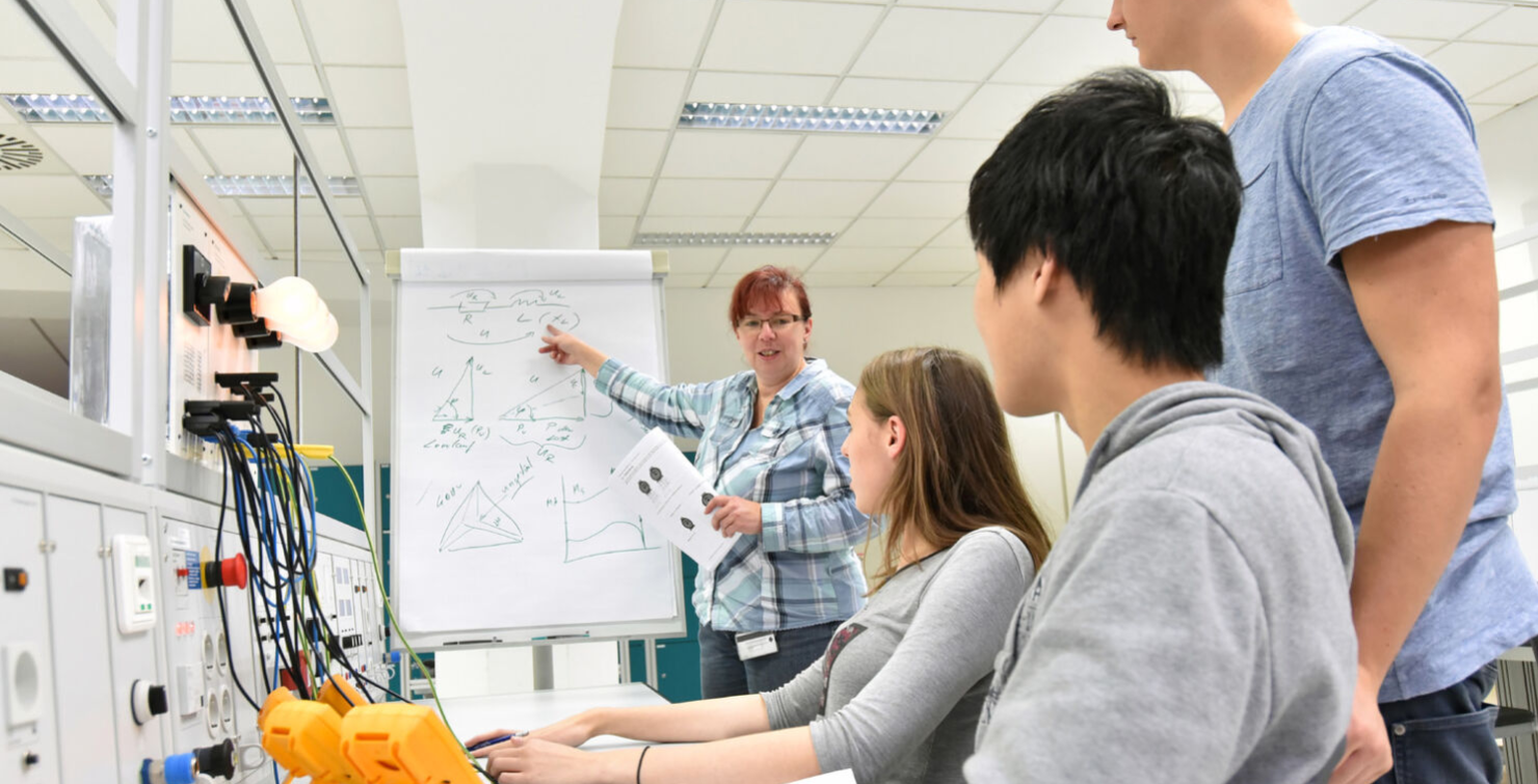 Estudiantes de electricidad recibiendo una clase de su profesora.