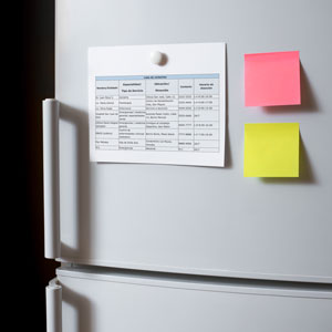 refrigeradora con hoja de papel adheridas a su puerta que representa una lista de contactos importantes.