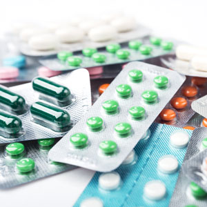 múltiples tabletas de medicamentos de colores y formas diferentes.
